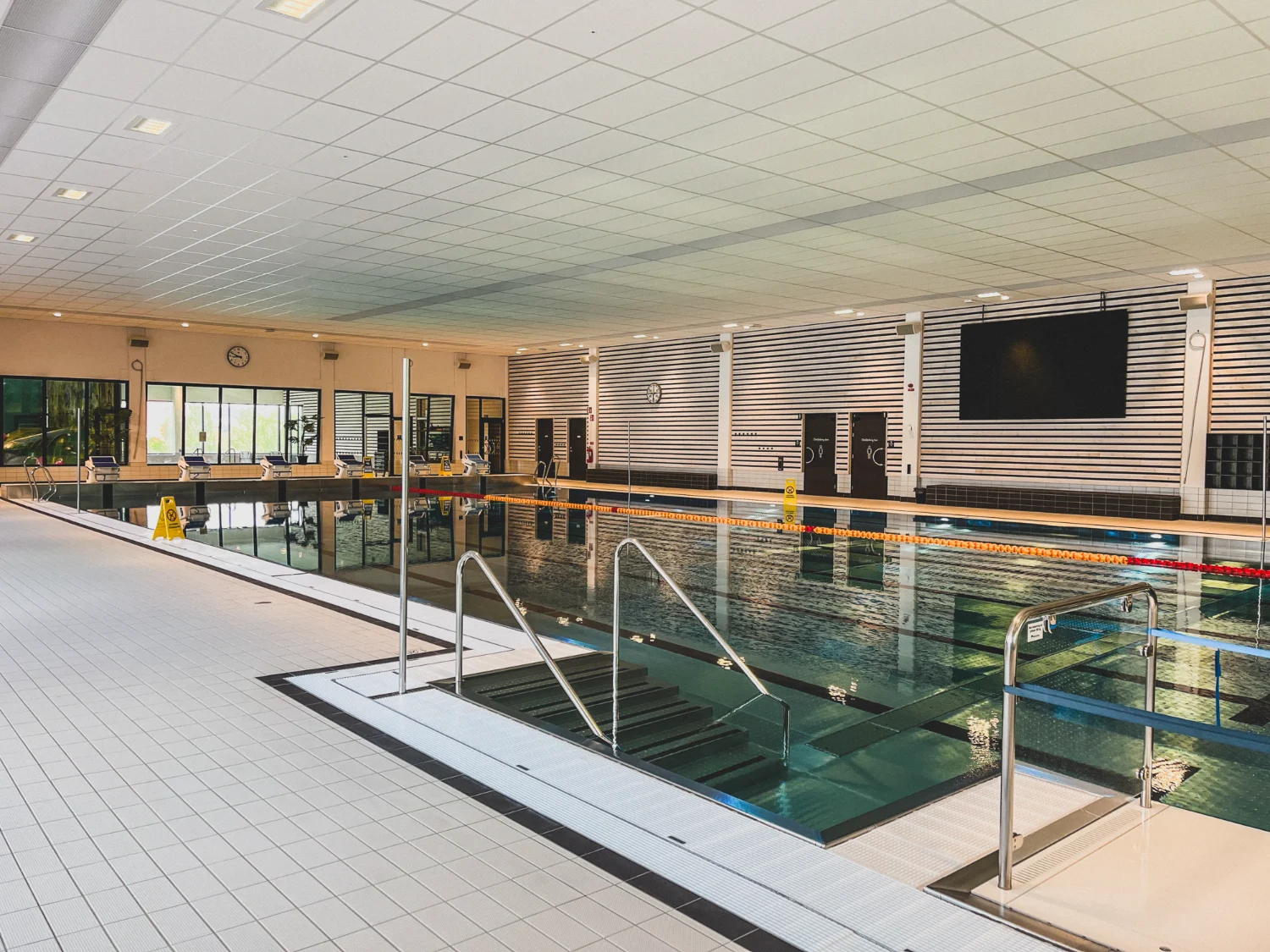 Badhus i Filipstad med ljudabsorbenter i tak och väggpaneler samt riktade högtalare över bassängen