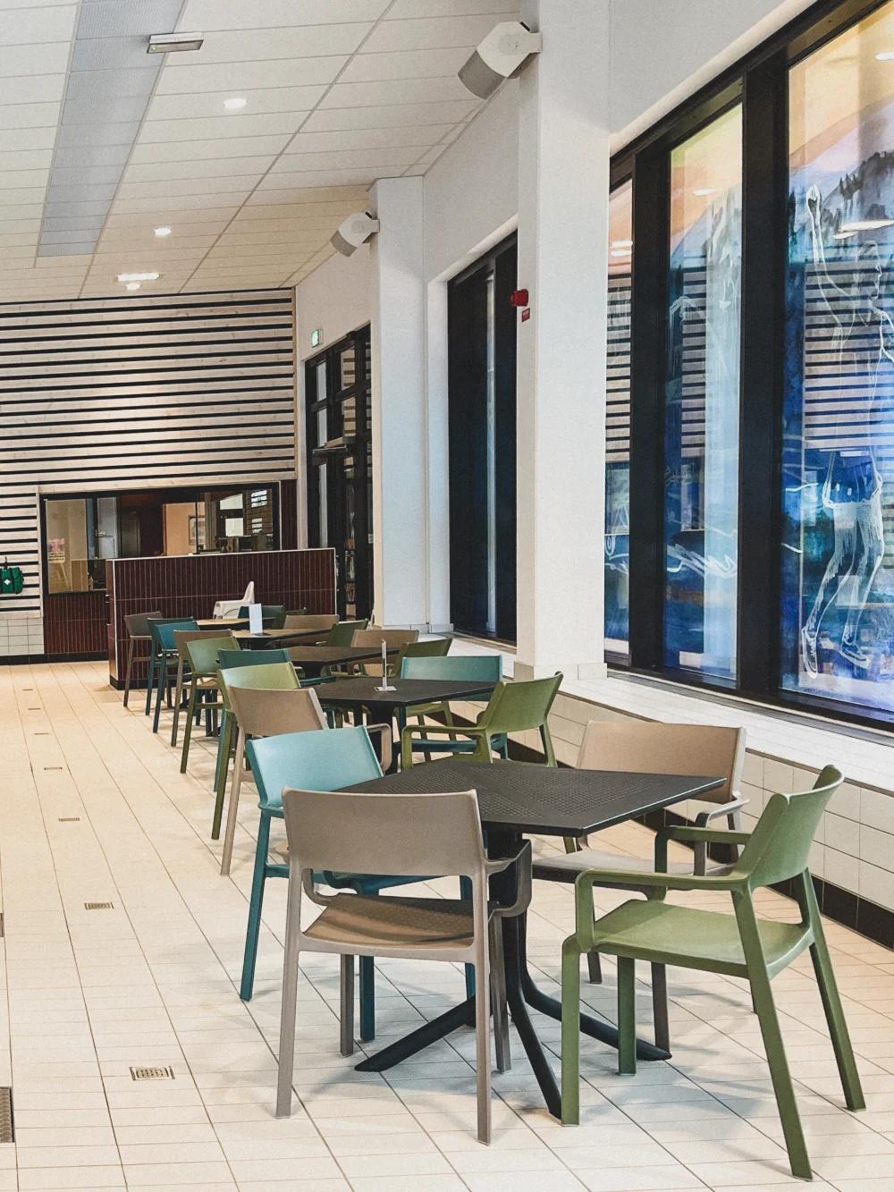 Riktade högtalare monterade i tak och på pelare i badhusets cafédel