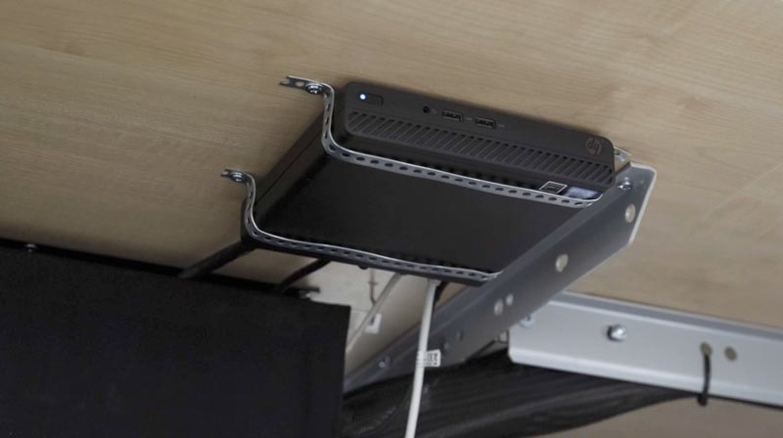 HP mini-PC monterad under konferensbordet.