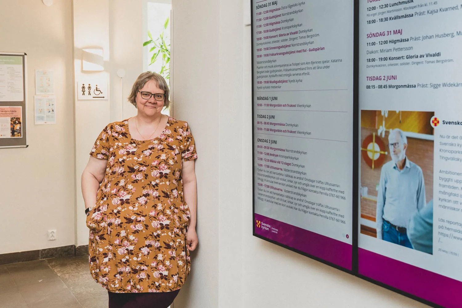 Louise Albrekt, kommunikatör på Karlstads pastorat, vid de digitala skärmarna i entrén.