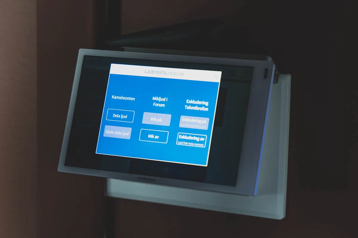 Crestron-pekpanel med ljudinställningar för mötesrummet.