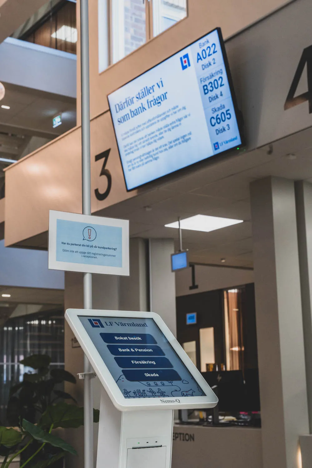 Självservicekiosk där besökare väljer ärende – Bokat besök, Bank & Pension, Försäkring eller Skada – under den digitala kösystemskärmen.